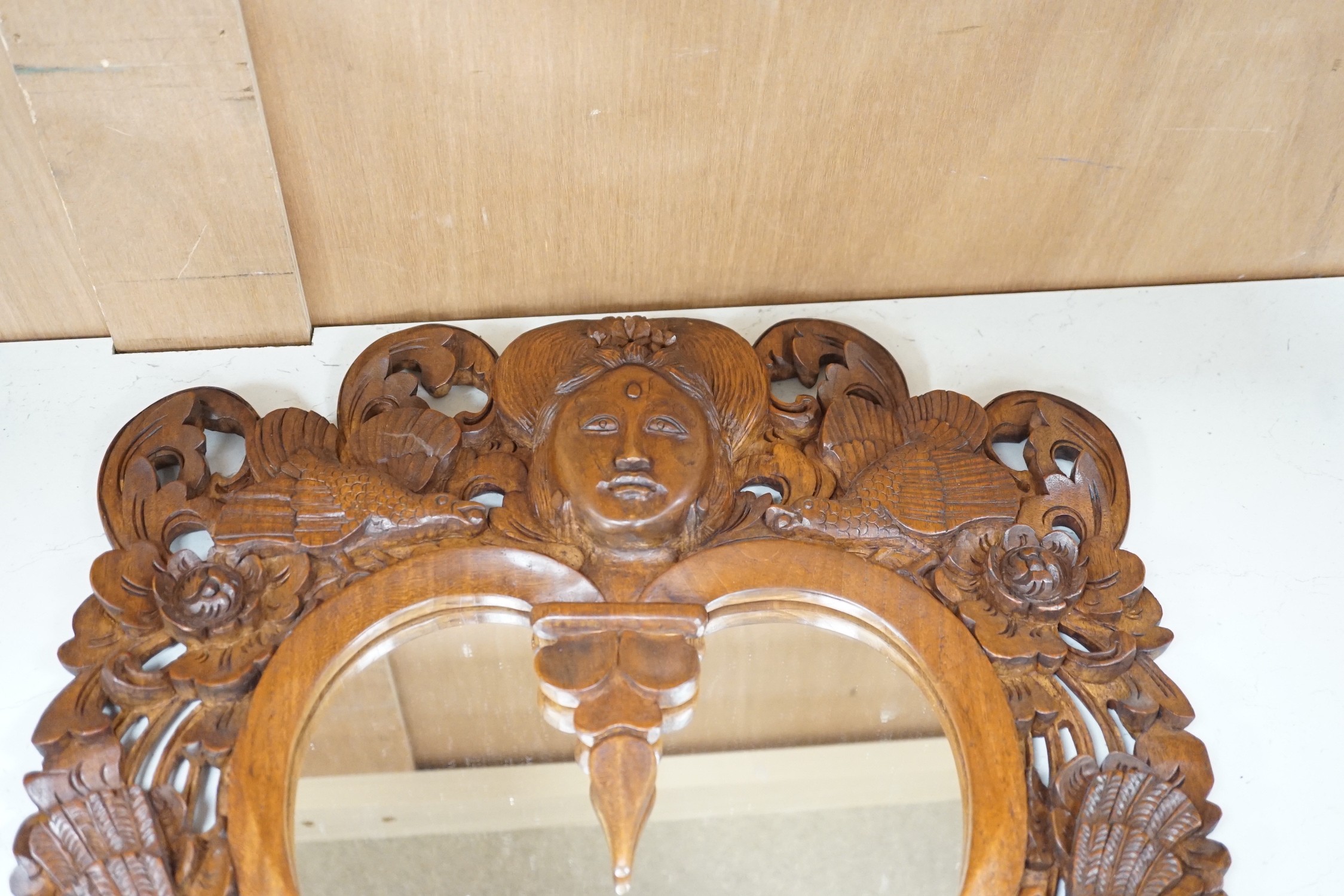 A Balinese carved wood wall mirror, 62cm long